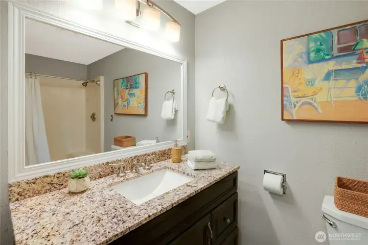 Primary en-suite with easy walk-in shower and granite vanity with space saving drawers