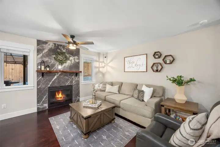 Inviting living room, off of the kitchen...featuring a cozy gas fireplace surrounded by elegant stone, creating the perfect gathering space.