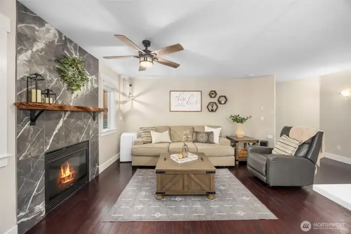 Inviting living room, off of the kitchen...featuring a cozy gas fireplace surrounded by elegant stone, creating the perfect gathering space.