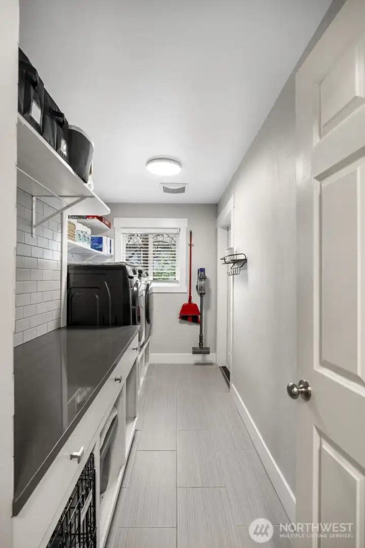 Large laundry room, off the garage with title flooring and quartz counter tops.