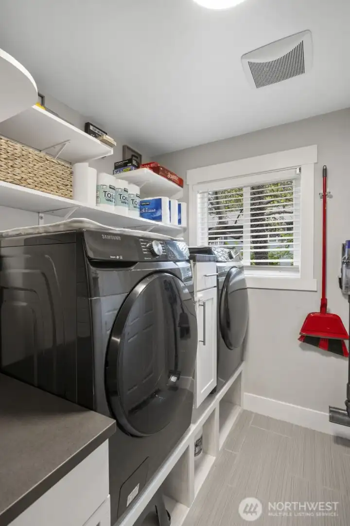 Large laundry room, off the garage with title flooring and quartz counter tops.