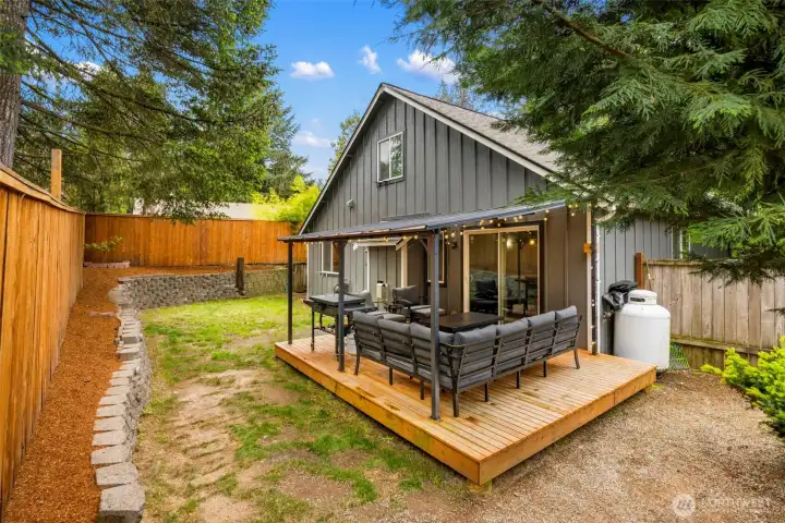 Fully fenced backyard with newly built covered outdoor porch, ideal for year-round indoor/outdoor living and entertaining.