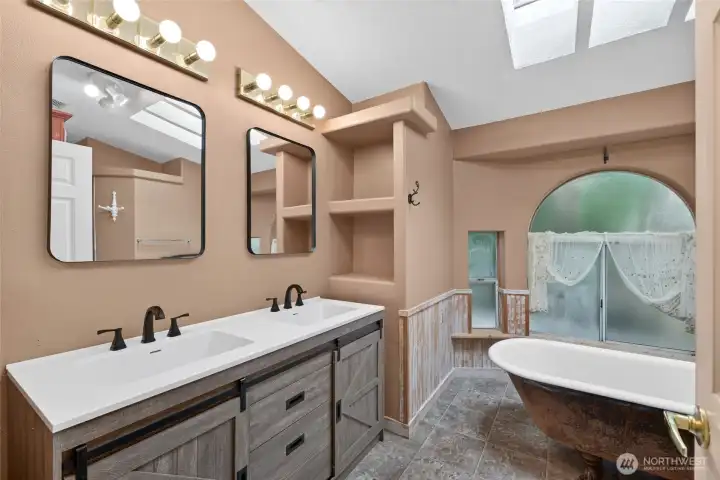 Primary bath with new double-sink vanity and mirrors, clawfoot tub and separate shower.