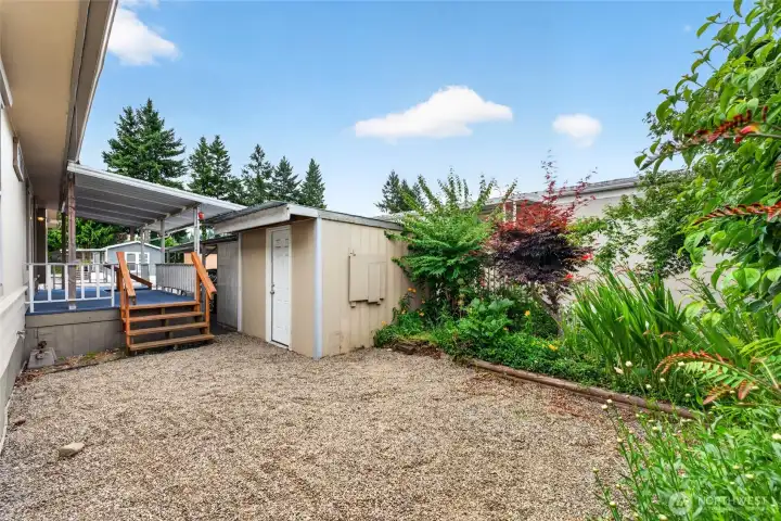 Second storage shed with attached exterior folding potting table provides ample storage.