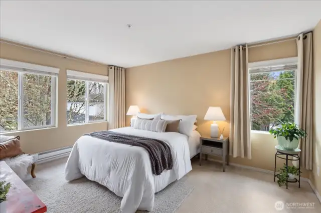 Primary bedroom also as an abundance of windows & custom curtains.