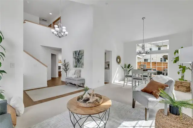 The soaring vaulted ceilings, open floor plan, and expansive windows flood the space with natural light, creating an airy, inviting atmosphere that feels bright and spacious throughout.