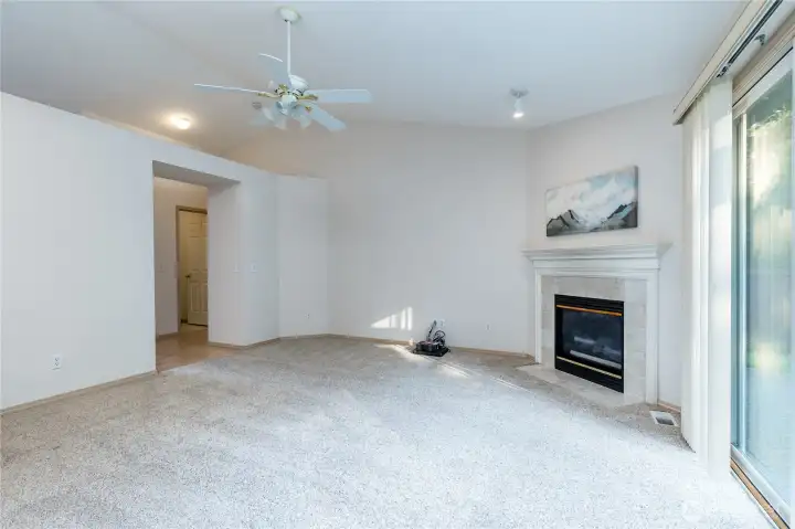 Spacious living room includes a gas fireplace with tiled surround