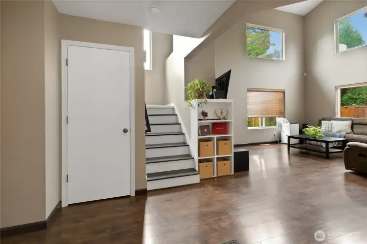 The entry way opens to glistening laminate floors and stairs, super high ceilings and windows abound.