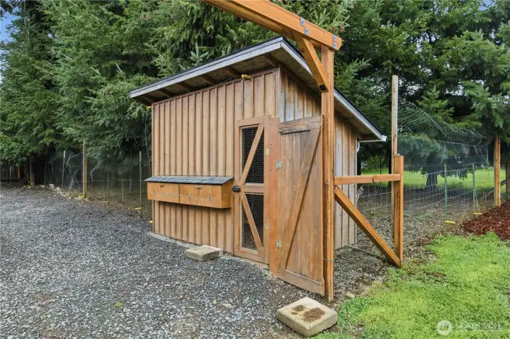 Large chicken coop and fenced in run area .
