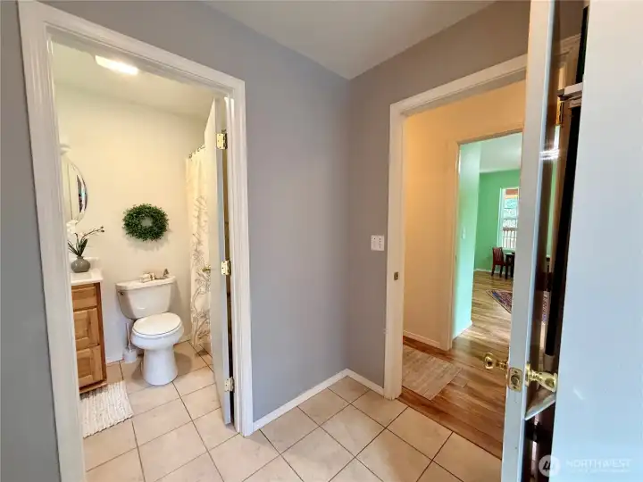 From the utility room, a view of the main floor full bathroom, then leading to the guest bedroom.