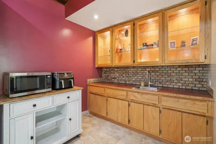 Kitchen with ample cabinetry and workspace, and a wet bar