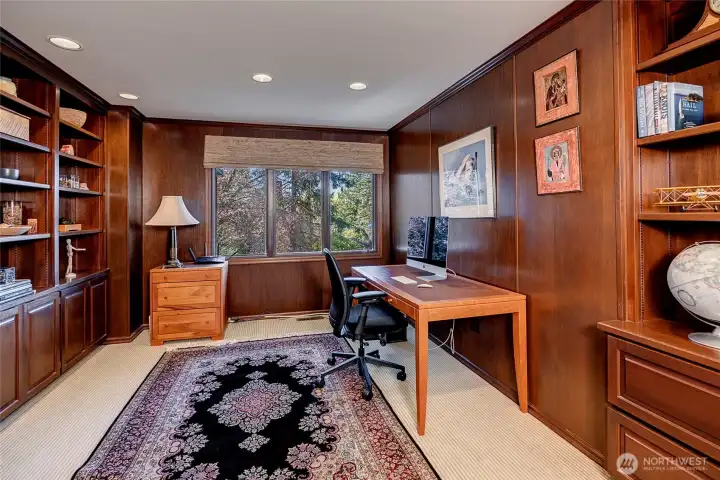 A true work from home office, this spacious and secluded paneled room is wrapped in warm wood, giving it a timeless, library like feel. Custom built in shelves provide abundant space for books and curated treasures