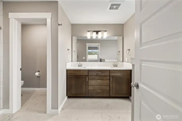 Primary Full Bathroom with separate tub and storage, double-sink vanity.