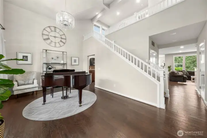 Soaring ceilings, a statement crystal chandelier, and rich hardwood floors set an impressive tone the moment you step inside — with an elegant staircase and open sightlines drawing you effortlessly into the heart of the home