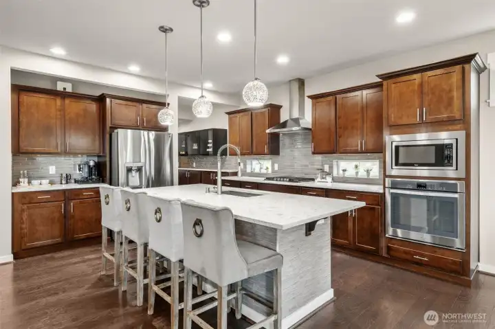 Abundant cabinetry wraps the entire kitchen, providing storage that finally matches the way real families cook — with a double wall oven, gas cooktop, and generous counter space on every run