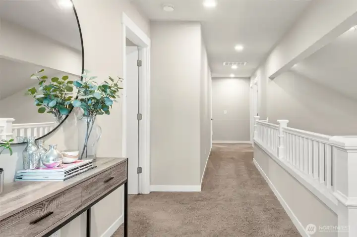 A wide, well-lit upper hallway with recessed lighting and plush carpet connects all upper level bedrooms with ease — the kind of thoughtful layout that makes a large home feel cohesive.