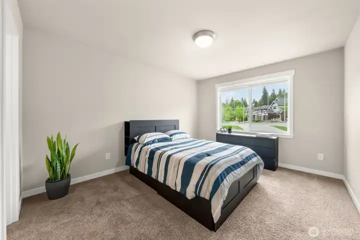 Bedroom 3 offers comfortable proportions, carpet, and a bright window overlooking the neighborhood — a well-sized space ready for guests, kids, or whatever the next chapter requires.