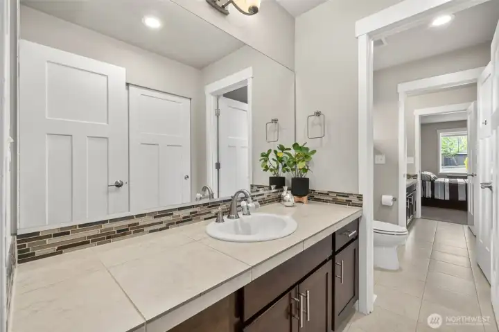 The second entry of the Jack and Jill bath mirrors the same quality finishes — tile flooring, extended countertop, and direct access to both bedrooms, making this upper level as functional as it is well-appointed.