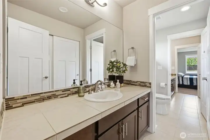The second entry of the Jack and Jill bath mirrors the same quality finishes — tile flooring, extended countertop, and direct access to both bedrooms, making this upper level as functional as it is well-appointed.