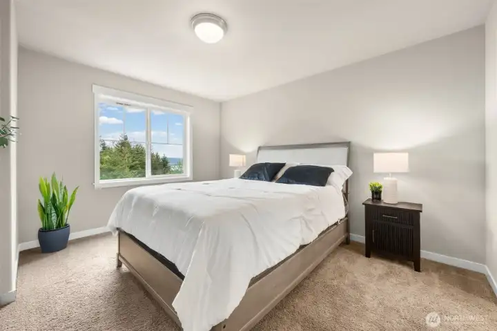 Bedroom 4 captures treetop and valley views through its window, bringing the outdoors in with a bright, quiet atmosphere well-suited for rest or focused work