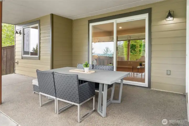 The covered lower patio offers a dedicated outdoor dining space with direct slider access to the home's interior — ideal for effortless indoor-outdoor flow whether you're hosting a dinner or enjoying a quiet morning outside.