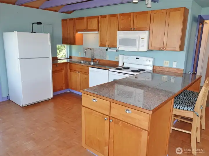 Kitchen w/ Eating Bar and Granite Tile Counters.