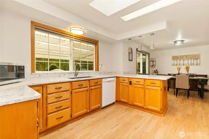 A spacious kitchen with a large, beautiful window that fills the space with natural light.