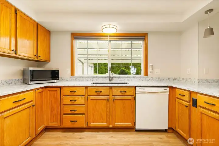 A spacious kitchen with a large, beautiful window that fills the space with natural light.