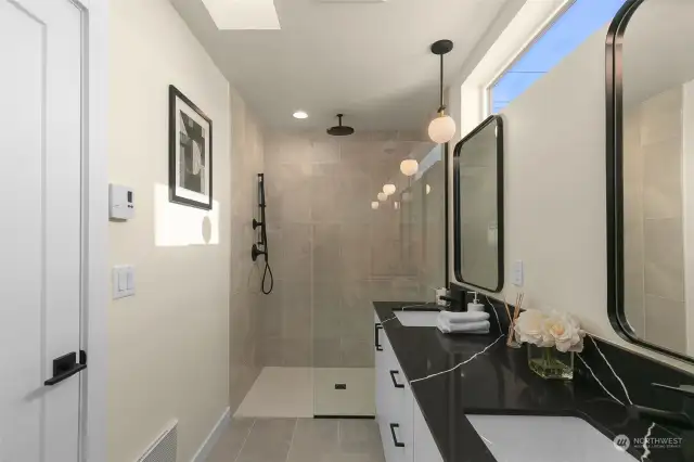 This bathroom sports gorgeous grey tile rain shower with clerestory windows for influx of natural light.
