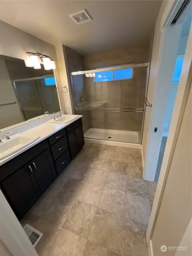 Primary bath with large walk-in shower and dual vanity