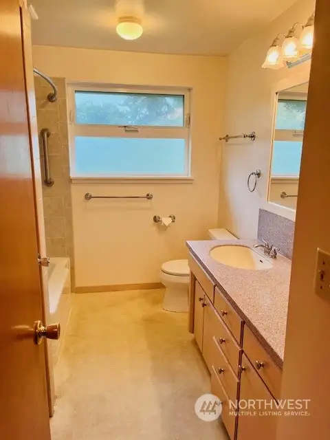 The full bathroom has been mostly updated (not original) with neutral colors.