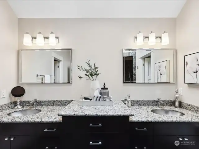 The bathroom features dual vanities with sleek granite counters, offering ample space for your daily routines. The radiant heated flooring provides a warm, inviting touch underfoot, perfect for chilly mornings.