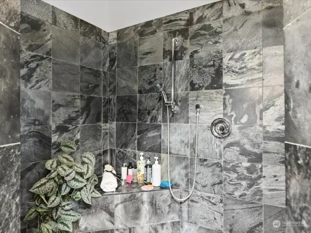 A beautifully tiled walk-in shower adds a spa-like ambiance, complete with modern fixtures. The spacious shower area ensures a refreshing experience every time.