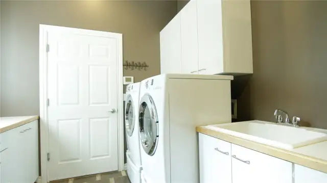 Formal Laundry Room with lots of cabinets for storage and a vanity sink