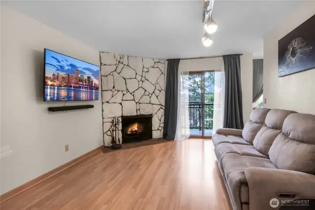 Living room with wood-burning fireplace and sliding door to the balcony.