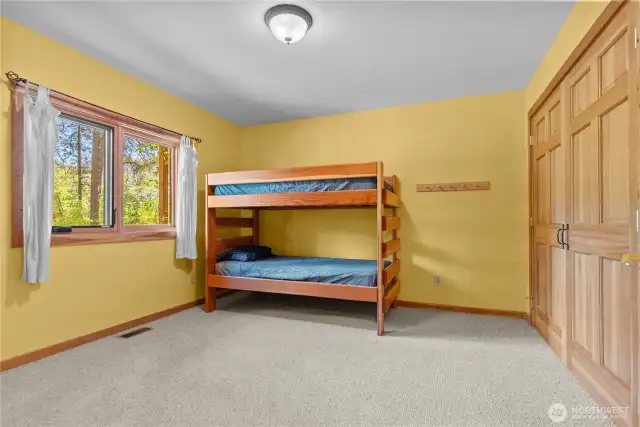 Bunk room with space for multiple guests and garden views.