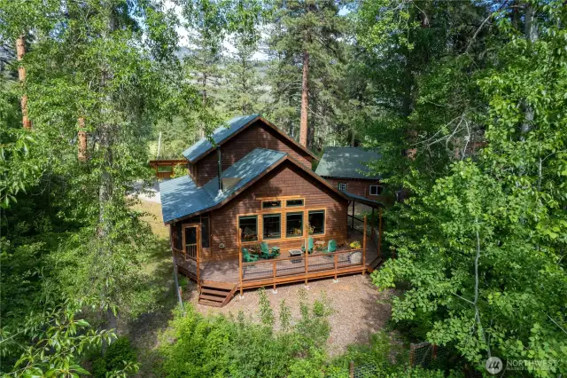 Cedar-sided home nestled in mature forest—secluded and serene. Private setting with large, sunny meadow near forest edge and highway access.