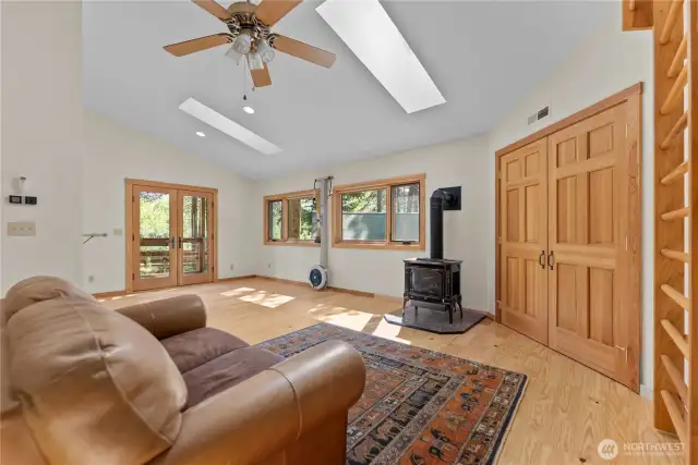Versatile upstairs bonus room with skylights, private balcony, and propane stove—ideal as a yoga room, office suite, or creative retreat. Includes dance bar and inspiring natural light.
