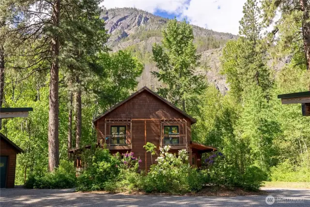 View of home and garage tucked against dramatic granite cliffs.