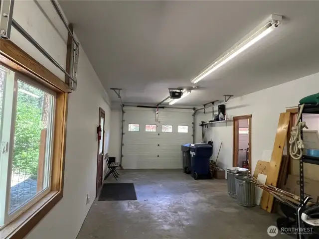 Interior of insulated garage two bay garage with built-in shelving and windows.