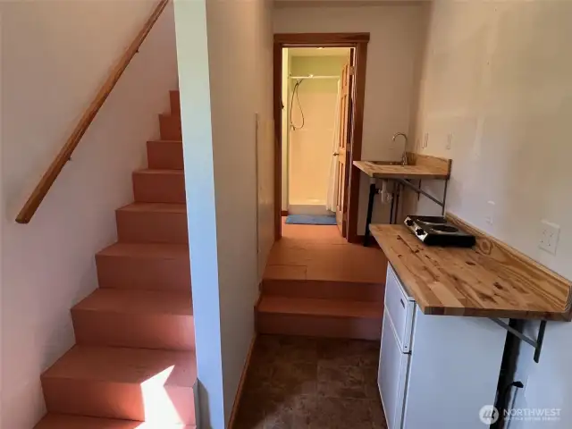 Garage kitchenette with wood counters and stairs to loft.