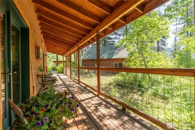 Welcome home—covered porch entry and lush plantings create a warm first impression. Covered porch extends living space with wildlife sanctuary setting—frequent visits from deer, birds, and small mammals.