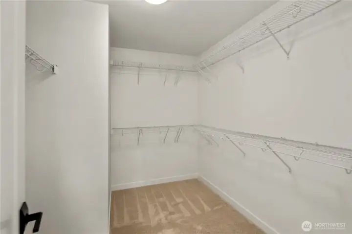 Primary Walk-In Closet: An expansive walk-in closet provides abundant hanging space and shelving to keep wardrobes organized with ease. Its size and layout allow for flexible storage solutions that fit modern lifestyles.  Staged photos are of the model home of the same floorplan within the Foxmoore community and are for visualization purposes only. Colors, finishes, and layout can and will vary.
