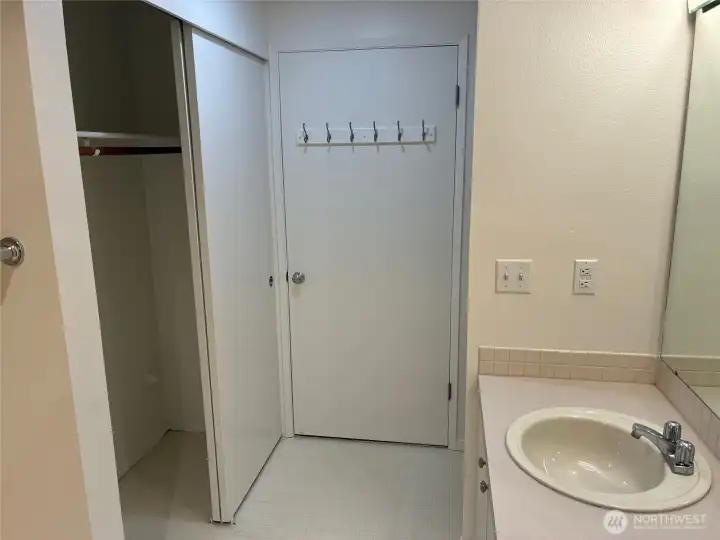 Large bathroom with walk in shower, second closet and storage shelves.