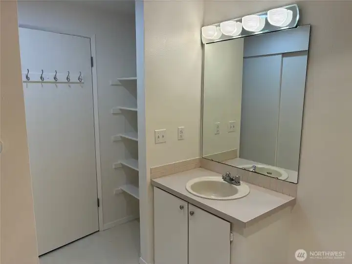 Large bathroom with walk in shower, second closet and storage shelves.