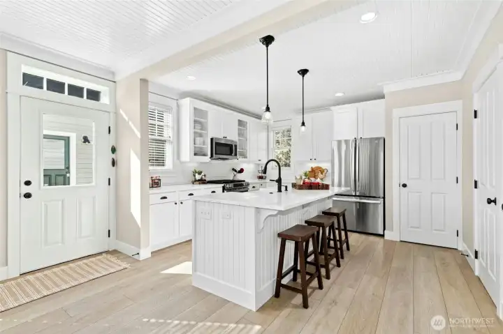 A sunny kitchen with an airy feel - the island and counter seating make it the perfect gathering spot after a day at the beach. Stainless appliances and a roomy pantry keep everything neat and easy.