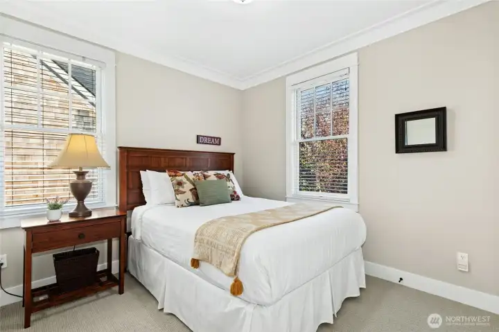The second-floor guest room includes a comfortable queen bed and enjoys easy access to a full bath just across the hall.
