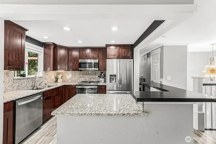 What a nice kitchen featuring newer microwave, range, dishwasher and garbage disposal, granite counters and updated lighting.