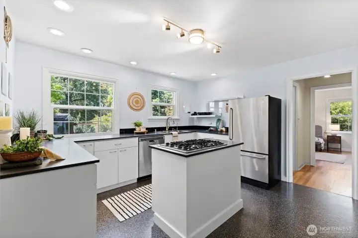 Bright and functional kitchen with stainless appliances, oversized windows, and modern finishes.
