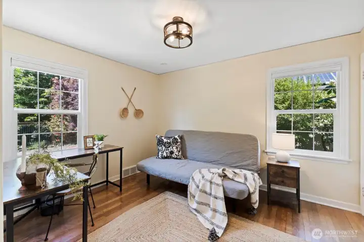 Flexible main level bedroom or office space with hardwood floors and abundant natural light.